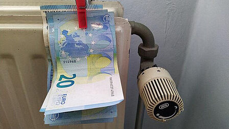 Radiator met briefjes geld eraan vast geknijperd