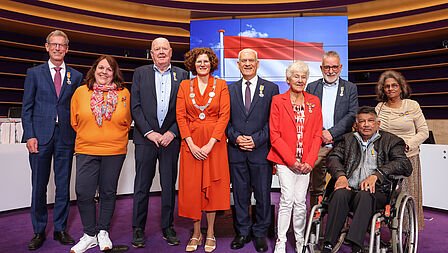Burgemeester Marijke van Beukering met om haar heen 8 genomineerden voor een Koninklijke onderscheiding