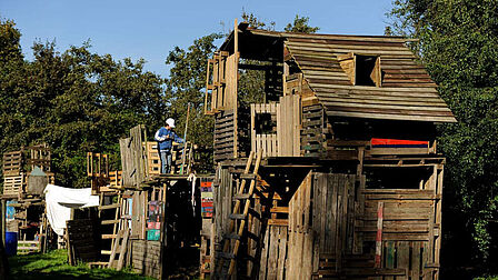 Jongen bouwt aan houten bouwwerk in een speeltuin