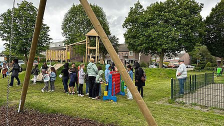 Groep mensen staan in een speeltuin