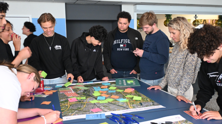 Jongeren beschrijven post-its en plakken ze op een kaart