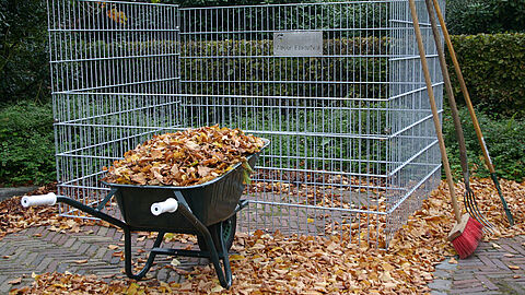Kruiwagen met herfstbladeren voor een bladkorf