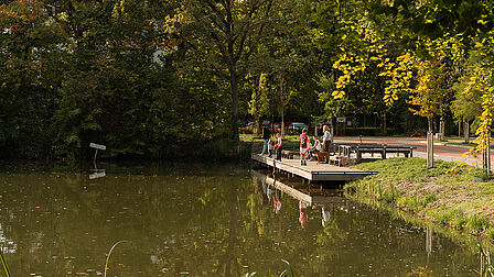 Mensen staan op een vlonder aan het water