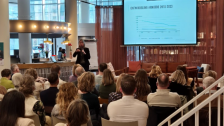Vrouw geeft een presentatie aan een groep mensen