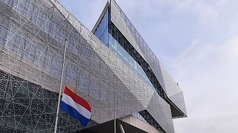 Decoratief beeld van het Stadshuis van Nieuwegein met de Nederlandse vlag halfstok