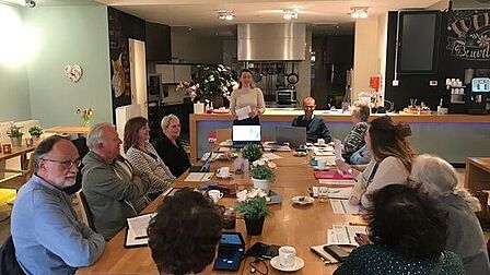 Mensen zitten aan een lange tafel