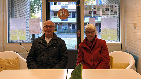 Twee ouderen zitten aan een tafel in het Muntpunt