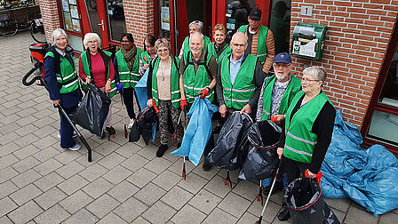 Groep mensen met grijpers en zakken