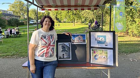 Vrouw staat voor kraampje met afbeeldingen