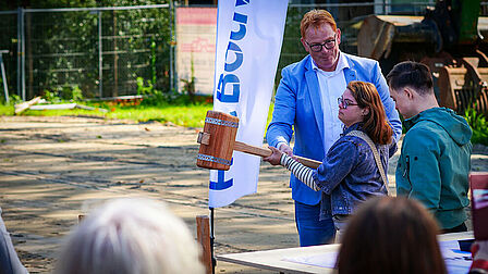 Jonge vrouw slaat met moker op heipaal