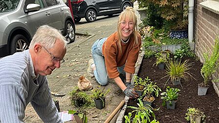 Foto van bewoners die bezig zijn met hun geveltuin
