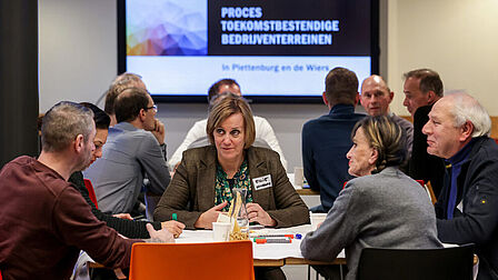 Wethouder Ellie Eggengoor zit aan tafel met een aantal mensen