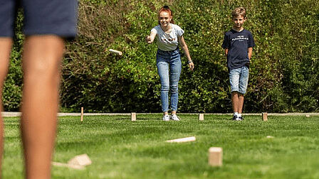 Mensen spelen kubb op een grasveld
