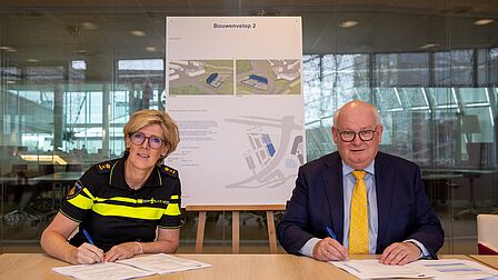 Mevrouw Petra Bosman, directeur van het Politie Diensten Centrum, en burgemeester Frans Backhuijs van gemeente Nieuwegein ondertekenen de overeenkomsten